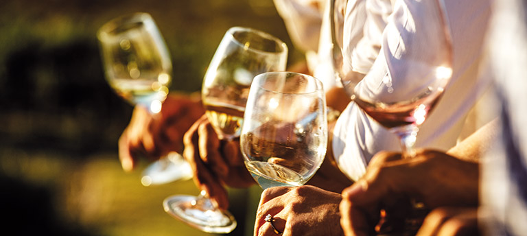 People holding glasses of white wine